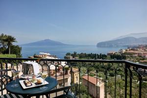 een tafel met een dienblad met eten op een balkon bij Grand Hotel Capodimonte in Sorrento