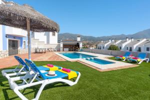 een achtertuin met een zwembad met stoelen en een parasol bij Villa Tia Ana by Villa Plus in Fuengirola
