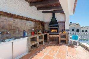 een buitenkeuken met een open haard en een patio bij Villa Tia Ana by Villa Plus in Fuengirola