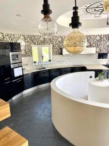 a kitchen with a large white tub in a room at One of the best properties in Lyme! Breathtaking views across the whole bay. 3 stories with 2 tier veranda around the property. Sleeps 6 in Lyme Regis