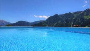 a swimming pool with mountains in the background at Gasthaus Alpina in Tschappina