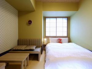 1 dormitorio con cama, banco y ventana en Onyado Nono Osaka Yodoyabashi, en Osaka