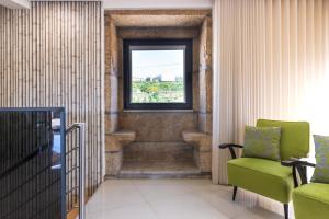 una escalera con una silla verde y una ventana en Casa Dona Maria - Armamar Douro, en Armamar
