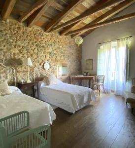 1 dormitorio con 2 camas, mesa y sillas en Bartró de Orfans, en Orfes