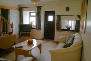 a living room with a couch and a table at Corehouse Farm Cottages - Dairy, Granary & Sawmill in Lanark