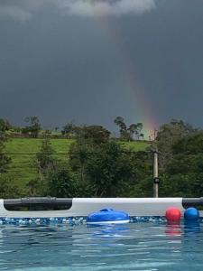 une piscine avec des balles bleues et rouges sur l'eau dans l'établissement Cabaña Milan, à San Gil