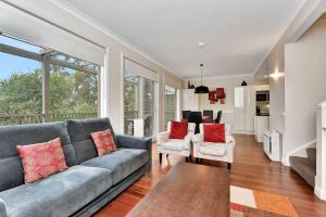 a living room with a gray couch and red pillows at Villa Executive 2br Cypress DS located within Cypress Lakes Resort in Pokolbin