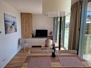 ein Wohnzimmer mit einem Esstisch und einem TV in der Unterkunft Apartamenty Szafirowe w Mielnie in Mielno