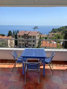 una mesa azul y sillas en el balcón en Medin Apartments BluVista en Petrovac na Moru