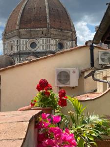 a domed building with flowers on a balcony at Al Campanile in Florence