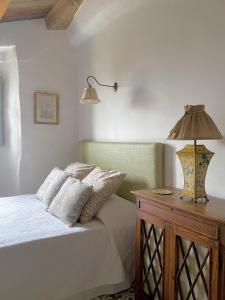 ein Schlafzimmer mit einem Bett und einer Lampe auf einem Holztisch in der Unterkunft Bartró de Orfans in Orfes