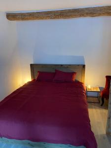 a bedroom with a large bed with purple sheets at SOLEIL ZEN in Grasse