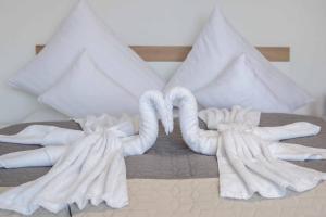 two swansuitsrendered to look like they are kissing on a bed at VillaNána in Tiszanána