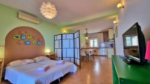 a bedroom with a bed and a television and a kitchen at Apartments Soric in Omiš