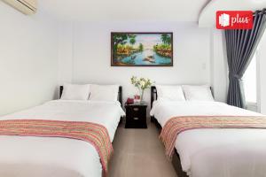 two beds sitting next to each other in a room at Saigon Pink Hotel in Ho Chi Minh City