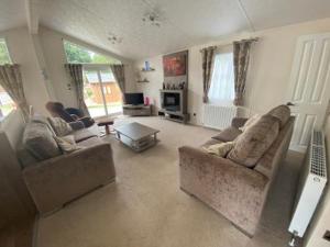 a living room with two couches and a tv at Liberty Lodge in Coleford