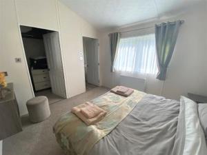 a bedroom with a bed with two towels on it at Liberty Lodge in Coleford