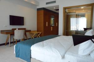 Ramada Plaza Hotel & Spa Trabzon في طرابزون: غرفة نوم بسرير وطاولة ومكتب