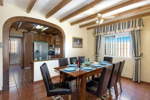 a dining room with a wooden table and chairs at Villa Torreon Faro by Villa Plus in Mijas Costa