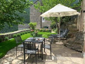 un tavolo e sedie con ombrellone su un patio di Medieval mountain setting with private garden a Colletta