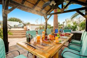 a wooden table with fruit and juice on a patio at Villa La Cala Playa by Villa Plus in La Cala de Mijas