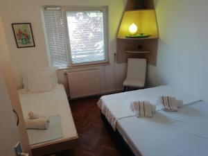 a room with two beds and a window at Pine Apartment in Gevgelija