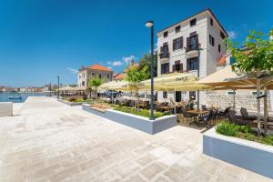 a patio with tables and chairs and umbrellas at Luxury Apartments Perko in Kaštela