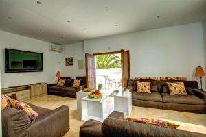 ein Wohnzimmer mit zwei Sofas und einem Fernseher in der Unterkunft Villa Cala Beach by Villa Plus in La Cala de Mijas