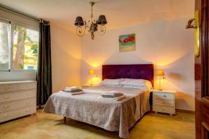 ein Schlafzimmer mit einem großen Bett mit einem lila Kopfteil in der Unterkunft Villa Cala Beach by Villa Plus in La Cala de Mijas + 27 Fotos