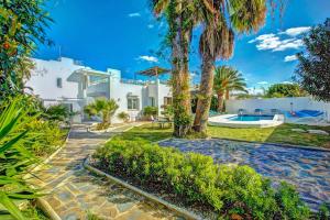 ein großes weißes Haus mit einem Pool und Palmen in der Unterkunft Villa Cala Beach by Villa Plus in La Cala de Mijas