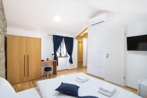 ein Wohnzimmer mit einem Bett und einem TV in der Unterkunft Istrian Casa Ladonia by Locap Group in Portorož
