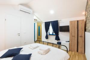 ein Schlafzimmer mit einem weißen Bett mit blauen Kissen in der Unterkunft Istrian Casa Ladonia by Locap Group in Portorož