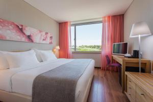 a hotel room with a bed and a desk and a window at HF Fénix Garden in Lisbon