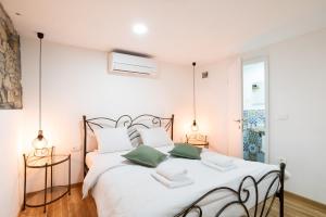 ein Schlafzimmer mit einem großen weißen Bett mit grünen Kissen in der Unterkunft Istrian Casa Ladonia by Locap Group in Portorož