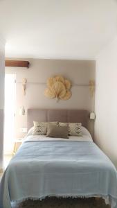 a bedroom with a large bed with a large flower on the wall at Hotel Nou Can Guillem in Cala Figuera
