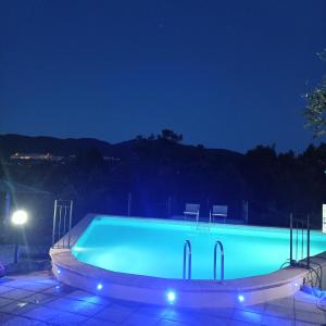 a swimming pool at night with chairs around it at Residence Grimani in Stroncone