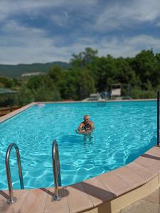 een man is in een zwembad bij Residence Grimani in Stroncone