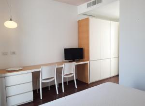 a room with two chairs and a desk with a television at Hotel Grecale in Porto Cesareo
