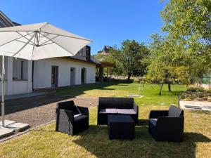 a patio with a table and chairs and an umbrella at Vitamin K73 Vendégház in Boldogkőváralja