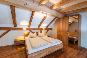 比希爾巴赫的住宿－Maisonett - Appartement 205，一间带一张床的卧室,位于带木制天花板的房间内