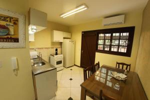 a kitchen with a table and a refrigerator and a dining room at Casa 25 (Dois Pinheiros) in Canela