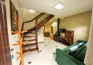 sala de estar con escalera de caracol y sofá verde en Casa 25 (Dois Pinheiros), en Canela