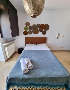 a bedroom with a bed with towels on it at Cosy 1bdr, with a terasse in heart of Sidibou in Sidi Bou Saïd