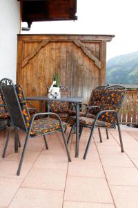 3 chaises et une table avec une plante en pot sur une terrasse dans l'établissement Appartement 103, à Bichlbach