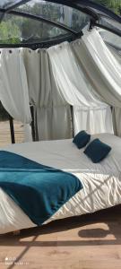 a white bed with blue pillows under a canopy at Les Perles Catalanes in Vinça +6 photos