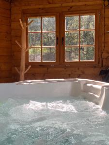 a bath tub in a room with windows at Les Perles Catalanes in Vinça