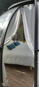 a white canopy bed with two blue pillows on it at Les Perles Catalanes in Vinça