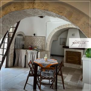 eine Küche mit einem Tisch und eine Treppe in einem Zimmer in der Unterkunft Trullo Eliana in Alberobello