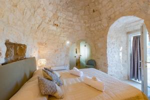 Villa Trulli Theodoro by Villa Plus tesisinde bir odada yatak veya yataklar