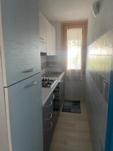ムラヴェーラにあるCasa Silviaのキッチン(白い冷蔵庫、コンロ付)